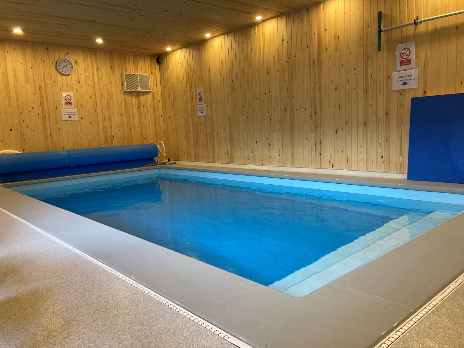 The small family pool, a warm indoor pool with cedar-clad walls and 0.9 metre depth signage